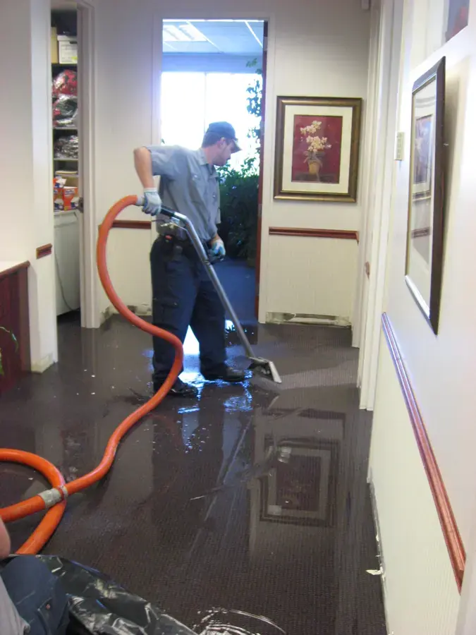 Technician extracting standing water from a hallway floor in Federal Way