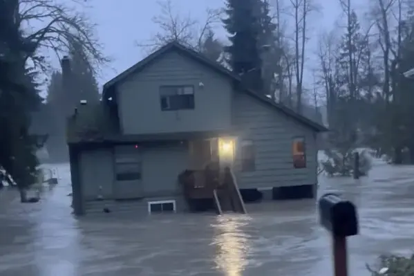 Rain flood water surrounding a home among evergreens during a Puget Sound storm